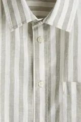 Camisa de manga larga con cuello inglés, a rayas verticales grises y blancas, con bolsillo en el pecho.