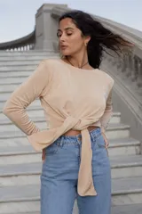 Remera beige de manga larga con nudo en la cintura.