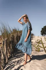 Vestido celeste de lino con mangas cortas y falda midi con volados de seda.