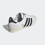 Championes Adidas Japan blancos con detalles en negro y beige. Diseño de cuero perforado con las tres tiras características de Adidas en los laterales.
