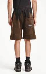 Bermuda negra de algodón rústico con calce oversize, elástico en la cintura y bolsillos con cierre.