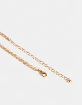 Collar corto dorado de doble cadena, una con círculos pequeños y otra con dije de metal con piedra azul.