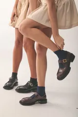 Zapatos Mary Jane color marrón con textura de cocodrilo, hebilla dorada y suela track.