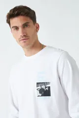 Remera de hombre de manga larga color beige, con estampado gráfico en el frente y escote redondo.