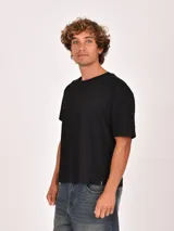 Remera negra de manga corta, con cuello redondo y corte holgado.