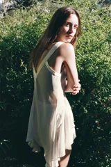 Top fluido color verde agua, de escote pico y tirantes anchos. Detalle de acabados satinados a contraste y bajo asimétrico con volados.