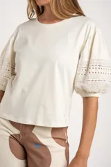 Remera negra de algodón con mangas 3/4 abullonadas con detalle de encaje calado. Corte al cuerpo.