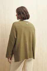 Sweater tejido color verde oliva con cruce irregular y botones a contraste.