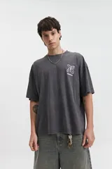 Remera gris de manga corta con corte boxy, cuello redondo y estampado en el pecho.