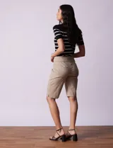 Bermuda color beige en gabardina elastizada, con pretina ancha elastizada, bolsillos simulados en la parte delantera y bolsillos aplicados en la parte trasera.