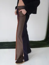 Pantalón de paño combinado con tira de cuero color naranja en los laterales.
