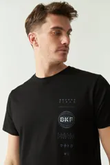 Remera negra de algodón con logo estampado en el pecho, corte regular, manga corta y cuello redondo.