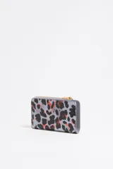 Monedero pequeño con estampado animal print en tonos lila, negro y naranja. Tiene cierre con cremallera dorada y logo de la marca en el frente. Interior con tarjetero y forro con logo grabado.