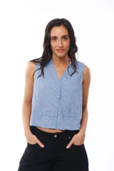 Blusa celeste sin mangas con escote en V y cierre frontal con botones. Presenta un diseño texturizado con líneas verticales y diagonales.