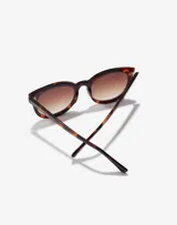 Gafas de sol Hawkers Resort unisex, con montura redonda de carey y lentes marrones degradadas.