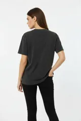 Remera corta de algodón con efecto lavado (acid wash) en color negro. Presenta un estampado frontal en blanco con texto "ROCK SOUL SINCE 2006 ON TOUR ROCK" y estrellas.