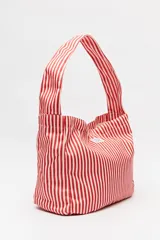 Bolso de hombro con estampado de rayas verticales celestes y blancas.