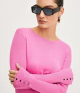 Suéter de punto color verde, con cuello barco, mangas largas y textura acanalada.