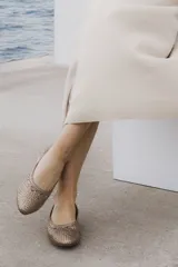 Zapato chata color dorado, trenzado a mano en cuero vacuno, con capellada, forro y plantilla de cuero vacuno.