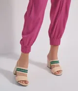 Pantalón jogger color crema de cintura alta con cierre y dos botones. Tiene elástico en la cintura, bolsillos aplicados y está confeccionado en viscosa.