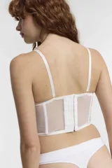 Corset blanco de encaje con copas preformadas, ballenas y tirantes regulables.