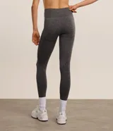 Conjunto deportivo seamless color gris compuesto por un top con tirantes finos y calzas largas con efecto push-up y detalle de lunares en los laterales.