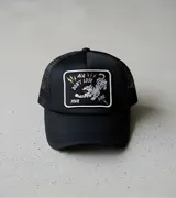 Gorra trucker negra con parche frontal bordado con un tigre y la frase "Don't Lose Your Fire".