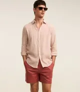 Bermuda masculina confeccionada en mezcla de algodón y lino, color beige. Presenta cintura elástica con cordón de ajuste, bolsillos laterales y un diseño liso de corte recto.