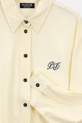 Camisa color crema de lino con botones y detalles bordados a contratono.