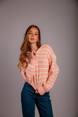 Sweater de punto color beige con rayas horizontales blancas, cuello polo con cierre de cremallera y mangas largas.