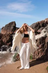 Triángulo de lana tejido a mano, color crudo, con flecos largos en todo el borde.