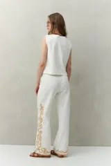 Pantalón recto negro de algodón con bordado artesanal blanco a contratono en los laterales y ruedo.