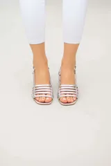 Sandalias negras de cuero con tiras finas entrecruzadas y taco geométrico.