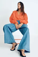 Pantalón culotte de denim azul claro, con cintura elástica fruncida, bolsillos laterales y corte holgado.