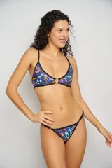 Corpiño de bikini triangular con estampado abstracto en tonos rosados y verdes, con aro metálico en el centro y breteles finos negros.