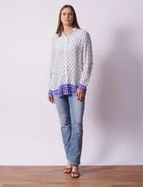 Camisa blanca con estampado floral en azul, de manga larga y cuello con solapa.
