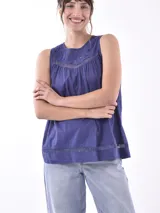 Blusa color durazno sin mangas, con cuello redondo y detalle de calado en la parte superior y en el ruedo.
