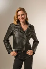 Chaqueta corta de cuero sintético negro con cuello solapa, cierre frontal asimétrico, bolsillos con cierre y tachas plateadas en cuello y hombros.