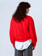 Sweater rojo de punto con mangas abullonadas y cuello redondo.