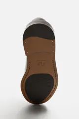Zapato de vestir tipo derby, color marrón oscuro, con cordones, capellada de cuero brillante, forro y plantilla de cuero y suela plana.