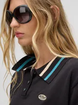 Chomba corta roja de algodón con cuello camisero con rayas celeste y negra. Logo bordado en el frente.