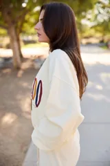 Sweater color crema con cuello redondo y estampado gráfico de montañas y la palabra "COLORADO" en el frente.