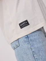 Remera rosa de algodón con estampado frontal con la frase 'Surf girl' y logo de la marca Rusty. Corte oversize.