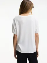Remera color durazno con degradé blanco, de punto con escote en V y mangas cortas.