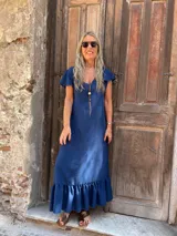 Vestido largo azul oscuro con escote en V, mangas cortas con volados y ruedo con volado.