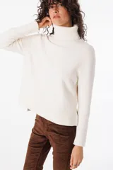 Sweater de polera en color crudo, suave al tacto, con corte relajado y ligero.