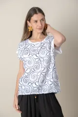Remera blanca con estampado de flores abstractas en azul marino. Confeccionada con lino en el frente y algodón en la espalda. De calce holgado y mangas cortas.
