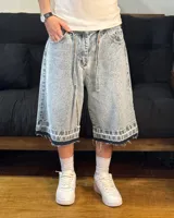 Bermuda de jean celeste matizado, corte baggy, con cordón ajustable en la cintura y detalle artesanal visible en el bajo.