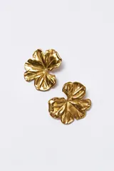 Aros tipo caravana dorados con forma de hoja estilizada.
