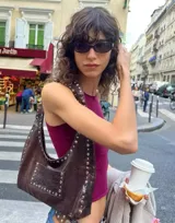 Bolso marrón de cuero con tachas plateadas.